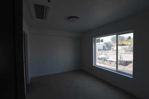 Spare room featuring carpet and baseboards