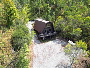 Aerial view of property and surrounding area with a heavily wooded area