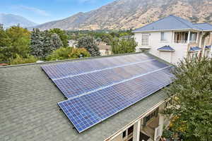 View of tennis court with a mountain view and a balcony