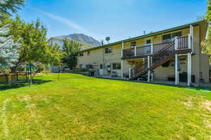Back of property featuring a patio area, stairs, brick siding, and a deck with mountain view