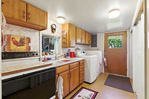 Washroom with washer and clothes dryer and electric panel