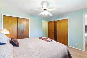 Carpeted bedroom featuring two closets and ceiling fan