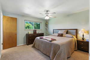 Bedroom with light colored carpet and a ceiling fan