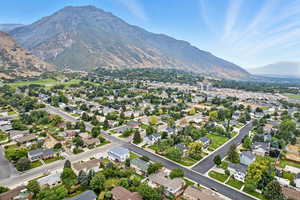 Aerial view of property and surrounding area featuring a mountain backdrop and nearby suburban area