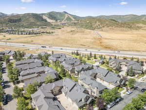 Aerial view of property and surrounding area with a mountainous background and nearby suburban area