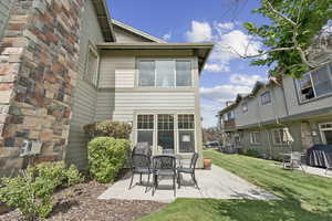 Rear view of house featuring a patio and a lawn
