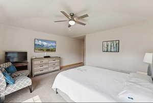 Carpeted bedroom with ceiling fan and baseboards