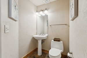 Bathroom featuring tile patterned flooring and a textured wall