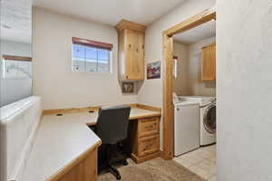Office featuring washer and dryer, built in desk, and light tile patterned floors