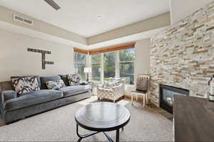 Living area featuring a stone fireplace and carpet