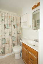 Full bathroom featuring vanity, light tile patterned floors, and shower / bathtub combination with curtain