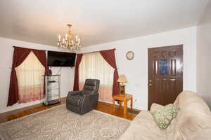 Living area featuring wood finished floors and a chandelier