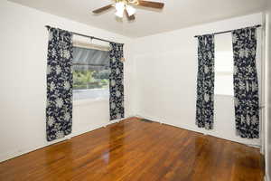 Empty room featuring dark wood finished floors and a ceiling fan