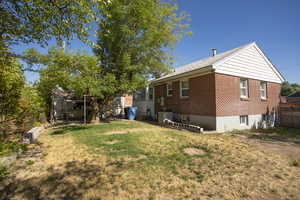 Rear view of property with brick siding