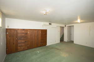 Unfurnished bedroom featuring carpet floors and wooden walls