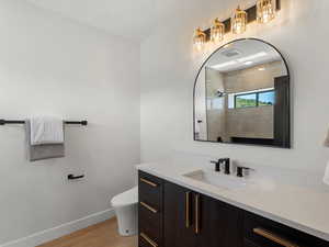 Full bathroom with vanity, light wood finished floors, and a tile shower