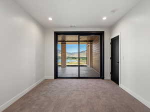Carpeted spare room with a water view and recessed lighting