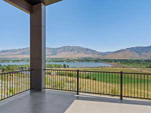 Balcony featuring a water and mountain view