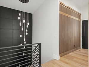 Hall featuring an upstairs landing and wood finished floors