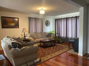 Living area featuring dark wood finished floors and baseboards