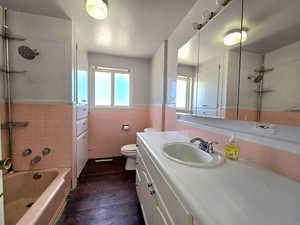 Main Level, Full bath with tile walls, vanity, shower / washtub combination, dark wood-type flooring