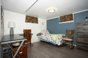 Bedroom with dark wood-type flooring and baseboards