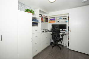 Office area with dark wood-type flooring and built in study area