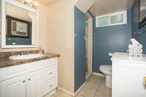 Full bathroom with vanity, light tile patterned floors, and a shower stall