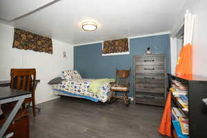 Bedroom with wood finished floors and baseboards