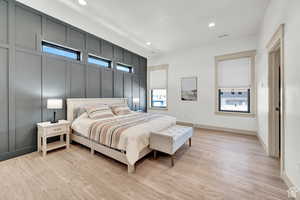 Bedroom featuring recessed lighting, light wood-style flooring, and a decorative wall