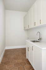 Laundry room featuring dark tile patterned flooring, hookup for a washing machine, and cabinet space