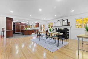 Dining space with recessed lighting, a fireplace, and light wood-style floors