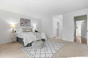 Bedroom featuring light colored carpet and baseboards
