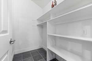 Spacious closet with dark tile patterned flooring