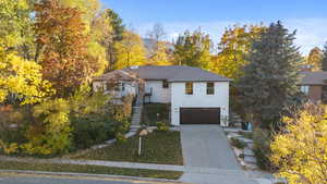 View of front of house featuring stairway, driveway, and a garage