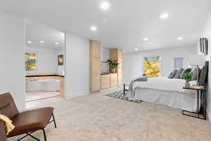 Bedroom with multiple windows, light colored carpet, and recessed lighting