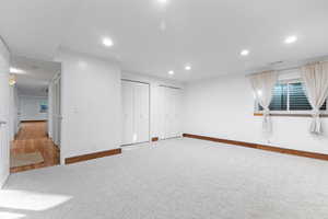 Below grade area featuring recessed lighting and light carpet