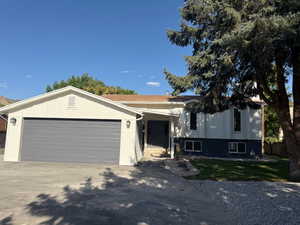 View of front of home with concrete driveway and a garage