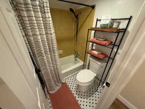 Full bathroom featuring shower / bath combo and tile patterned flooring
