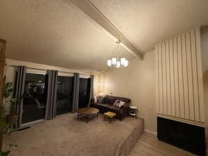 Living area with a textured ceiling, light wood finished floors, and a chandelier