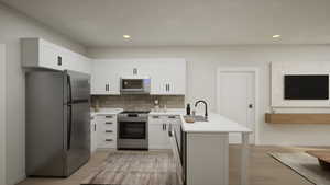 Kitchen featuring freestanding refrigerator, decorative backsplash, a peninsula, stainless steel gas range, and recessed lighting