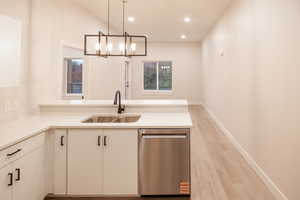 Kitchen featuring dishwasher, recessed lighting, decorative light fixtures, light wood-type flooring, and a peninsula