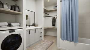 Washroom featuring washer / dryer and light wood-style flooring