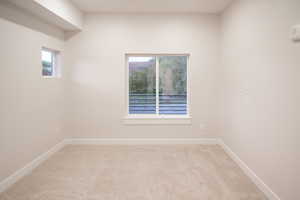 Spare room featuring light carpet and plenty of natural light