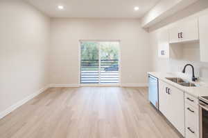 Kitchen featuring white cabinets, recessed lighting, light wood finished floors, and appliances with stainless steel finishes