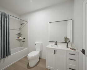 Bathroom with shower / bath combo, wood finished floors, and vanity