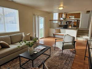 Living area with light wood-type flooring, stairs, and a textured ceiling