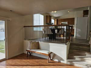 Stairs featuring wood finished floors, lofted ceiling, a textured ceiling, and recessed lighting