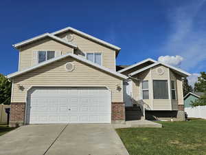 Traditional home featuring driveway and brick siding
