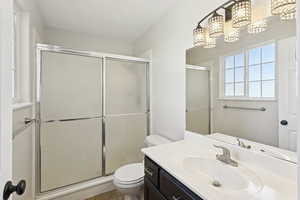 Full bath with vanity, a shower stall, and light tile patterned floors